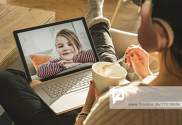 Kleines Mädchen lächelt während eines Videogesprächs auf dem Laptop-Bildschirm