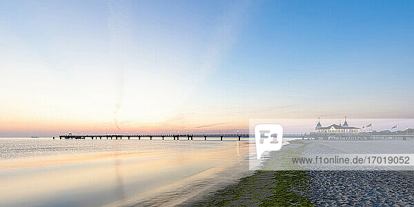 Deutschland  Mecklenburg-Vorpommern  Ahlbeck  Sandstrand bei Sonnenaufgang mit Seebrücke im Hintergrund
