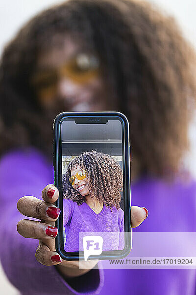 Afro-Frau zeigt Selfie durch Mobiltelefon