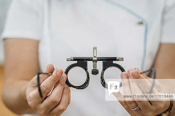Female optometrist holding eye checking glasses at hospital