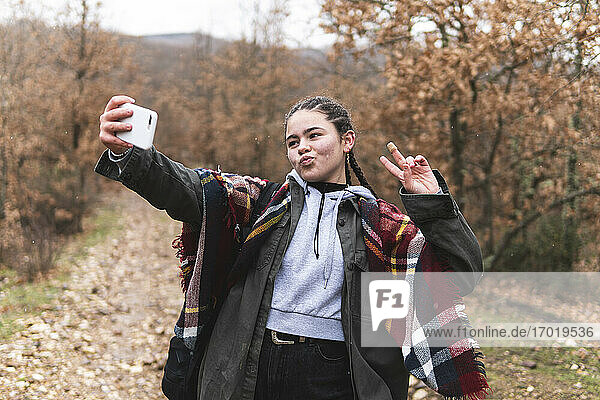 Teenager-Mädchen nimmt Selfie in Herbstlandschaft