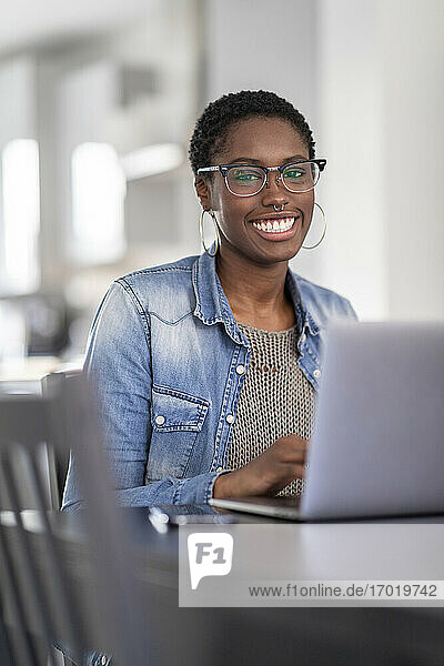 Smiling woman working on laptop at home