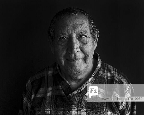 Lächelnder älterer Mann vor schwarzem Hintergrund