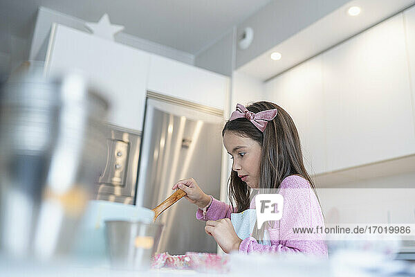 Little girl preparing muffin at home