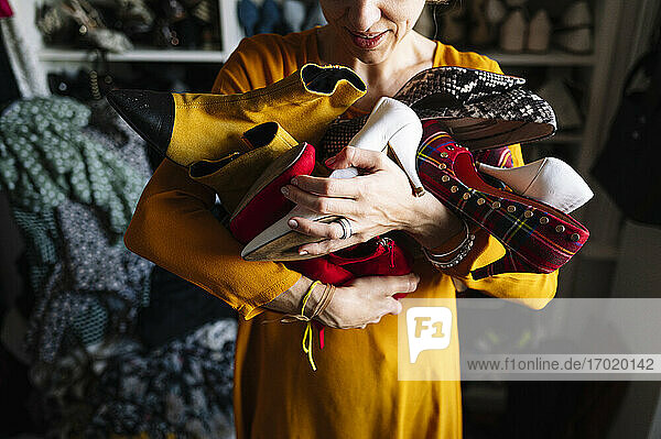 Frau trägt Variation von Schuhen im Kleiderschrank zu Hause