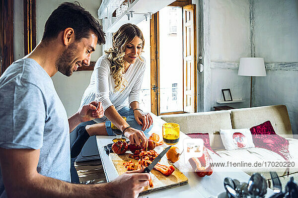 Young man preparing food with girlfriend at home