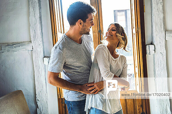 Zärtliches junges Paar tanzt im Wohnzimmer zu Hause