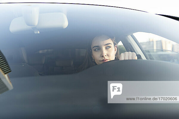 Junge Geschäftsfrau schaut weg  während sie im Auto sitzt