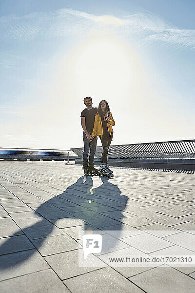 Junger Mann mit Frau auf dem Pier stehend gegen den Himmel an einem sonnigen Tag