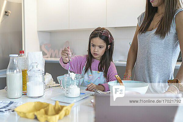 Tochter bereitet hausgemachte Muffins mit Mutter in der Küche zu