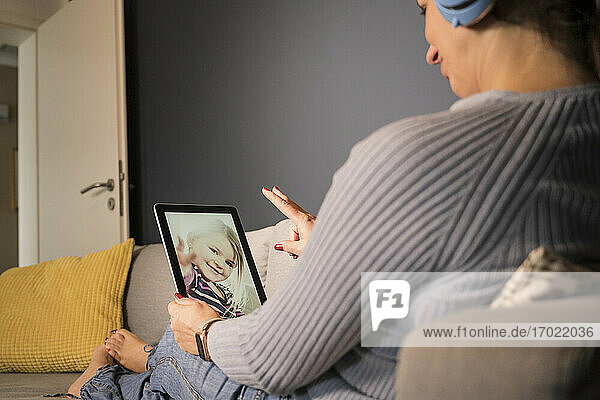 Mutter und Tochter führen einen Videoanruf über ein digitales Tablet zu Hause