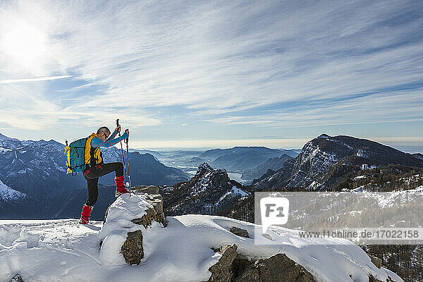 Männlicher Wanderer klettert auf dem Gipfel eines Berges gegen den Himmel  Orobische Alpen  Lecco  Italien