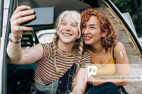 Lesbian couple smiling and taking selfie