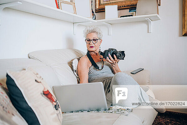 Fotograf arbeitet zu Hause am Laptop