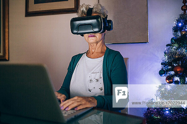 Frau mit Virtual-Reality-Headset und Laptop