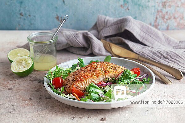 Fried salmon fillet on a mixed leaf salad