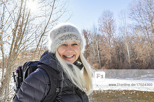 USA  Idaho  Sun Valley  Winterporträt einer lächelnden Frau beim Wandern am Fluss