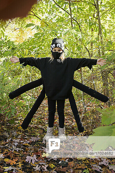 Mädchen (8-9) trägt Halloween-Kostüm im Wald
