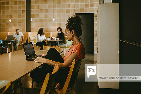 Businesswoman using laptop while working in coworking office