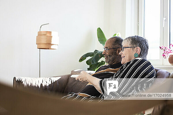 Glückliches Paar beim Fernsehen im Wohnzimmer