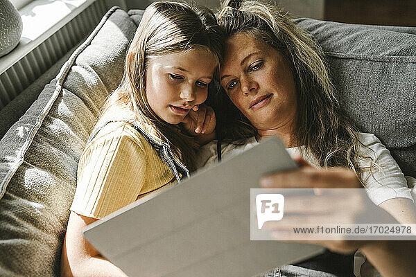 Mutter und Tochter verwenden digitales Tablet zu Hause
