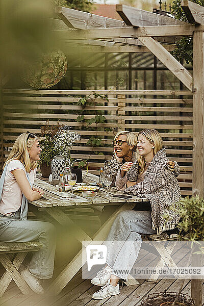 Weibliche Freunde verbringen Zeit mit Großmutter am Tisch im Hinterhof