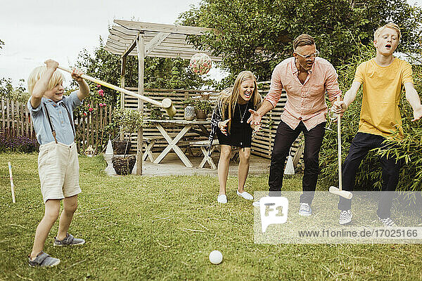 Fröhliche Familie spielt Polo im Vorgarten
