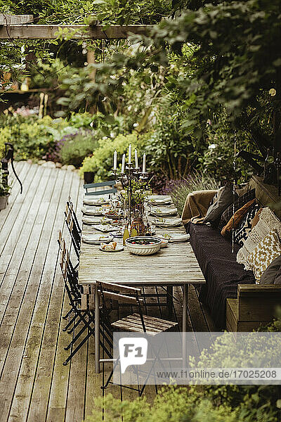 Dining table arranged by plants in back yard for party