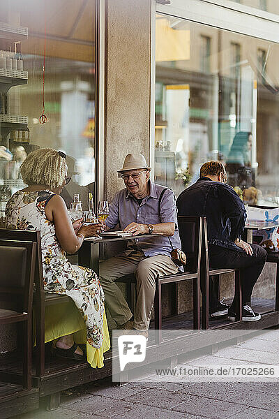 Heterosexual couple sitting in sidewalk cafe