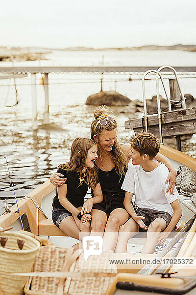 Glückliche Familie sitzt im Boot während des Sommerurlaubs