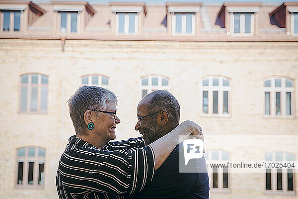 Lächelnde Senior Paar umarmt einander in Balkon