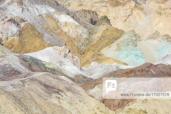 Visitor dwarfed by landscape of colourful rocks  Artist's Palette  Furnace Creek  Death Valley National Park  California  United States of America  North America