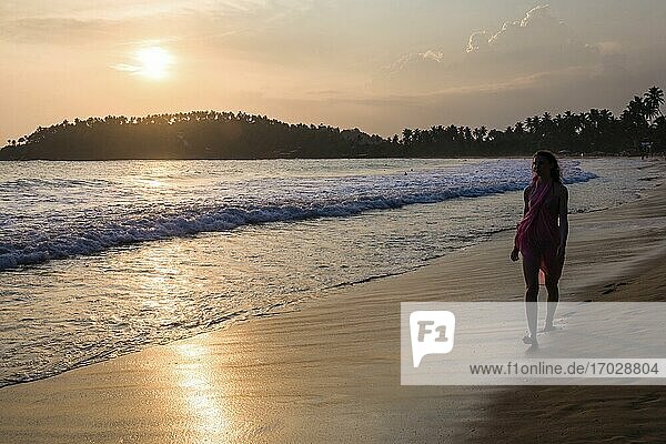 Mirissa  Frau im Urlaub am Strand von Mirissa bei Sonnenuntergang  Südküste von Sri Lanka  Südprovinz  Asien