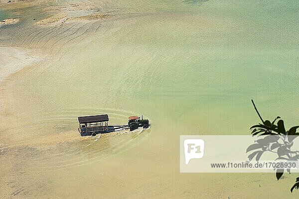 Touristen auf dem Weg zum Touristenboot am East Railay Beach  Südthailand. Railay Beach (Rai Leh Beach) ist ein atemberaubendes thailändisches Urlaubsziel in der Nähe von Krabi  an der Andamanenküste Thailands. Das tropische Paradies Railay (Rai Leh)  das nur mit einem traditionellen thailändischen Boot erreichbar ist  weil es von riesigen Kalksteinkarstfelsen umgeben ist  beherbergt eine Reihe wunderschöner exotischer Strände  darunter Ao Phra Nang  East Railay und West Railay Beach.