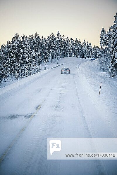 Autofahrt auf vereisten  schneebedeckten Straßen während einer Reise in Lappland innerhalb des Polarkreises in Finnland