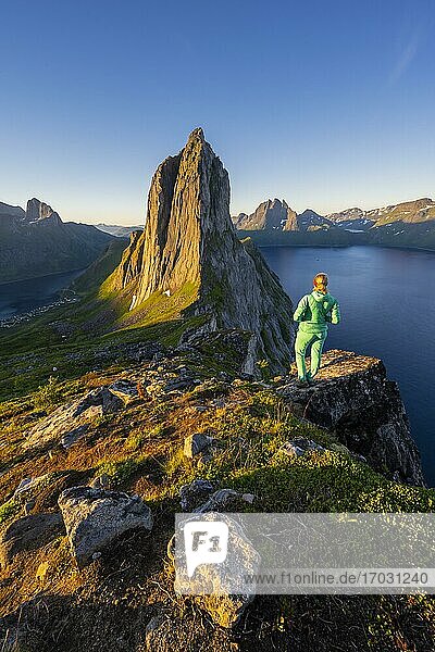 Morgenstimmung  Wanderin blickt auf Landschaft  steiler Berg Segla  Fjord Mefjorden mit Bergen  Insel Senja  Troms  Norwegen  Europa