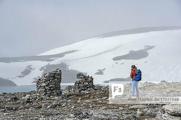 Tundra  karge Landschaft  Wanderin auf Wanderung zum Berg Snøhetta  Mauerreste einer alten Steinhütte  Dovrefjell Nationalpark  Oppdal  Norwegen  Europa
