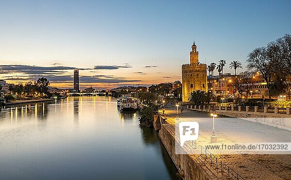 View over the river Rio Guadalquivir with Torre del Oro  promenade and Puente de Triana  in the back Torre Sevilla  sunset  blue hour  Sevilla  Andalusia  Spain  Europe