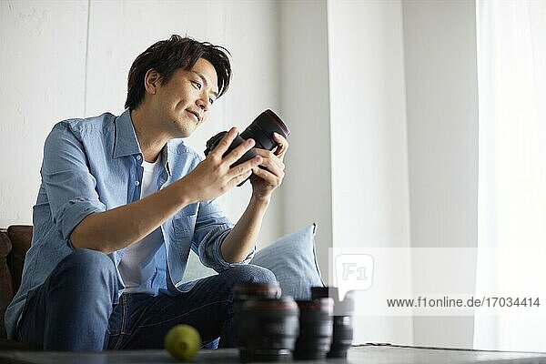 Japanese man cleaning camera at home