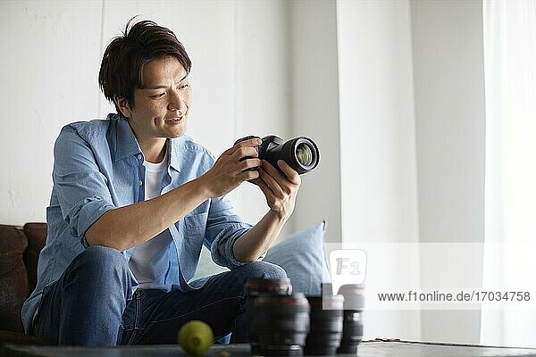 Japanischer Mann reinigt Kamera zu Hause