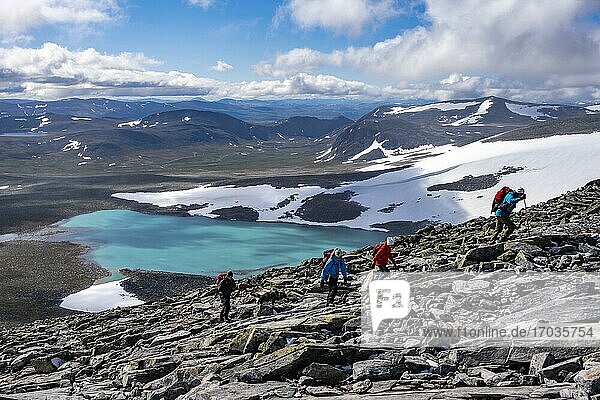 Tundra  barren mountain landscape with mountain lake  Hiker on hike to Snøhetta mountain  Dovrefjell National Park  Oppdal  Norway  Europe