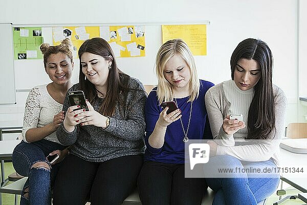 Vocational school students with their smartphones during break at the Elly-Heuss-Knapp-Schule  a vocational college of the city of Düsseldorf  North Rhine-Westphalia  Germany  Europe