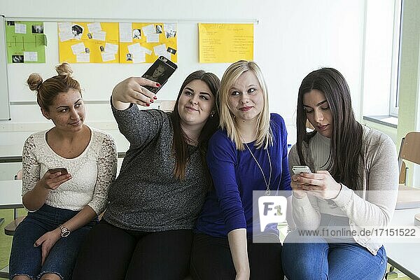 Berufsschülerinnen mit ihren Smartphones während der Pause in der Elly-Heuss-Knapp-Schule  ein Berufskolleg der Stadt Düsseldorf  Nordrhein-Westfalen  Deutschland  Europa