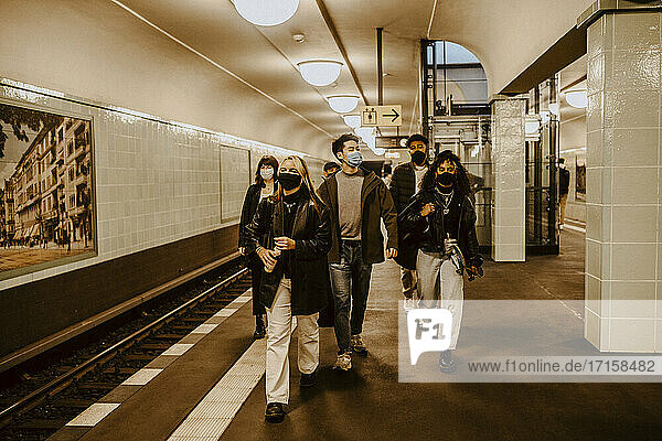 Junge Freunde gehen an der U-Bahn-Station während der Pandemie