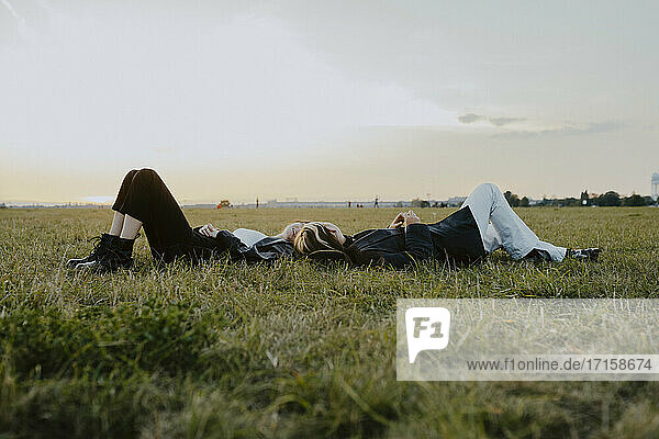 Weibliche Freunde liegen auf Gras im Park