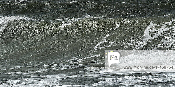 Carefree man surfing on sea at Broad Haven South Beach  Wales  UK