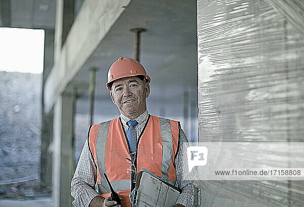 Mature male architect standing at construction site