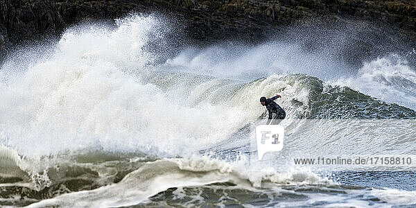 Unbeschwerter Mann beim Surfen auf den Wellen am Broad Haven South Beach  Wales  UK