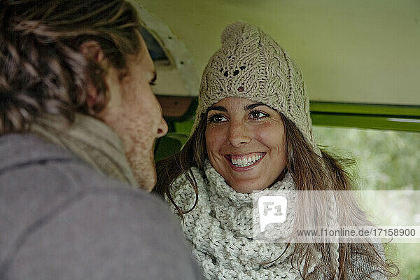 Smiling woman talking with man in camper van during road trip