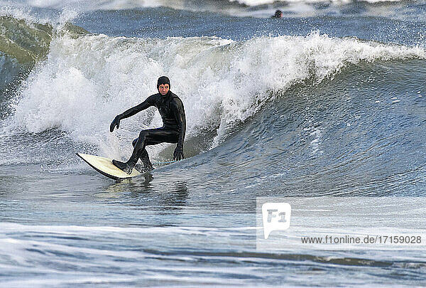Mittlerer Erwachsener mit Neoprenanzug beim Surfen auf dem Meer  Broad Haven South Beach  Wales  UK